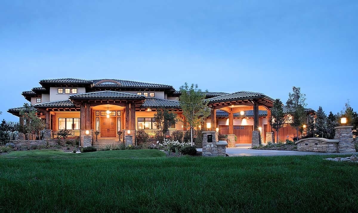 House plan exterior: Ranch style with covered entry, extensive rooflines, and attached three-car garage.