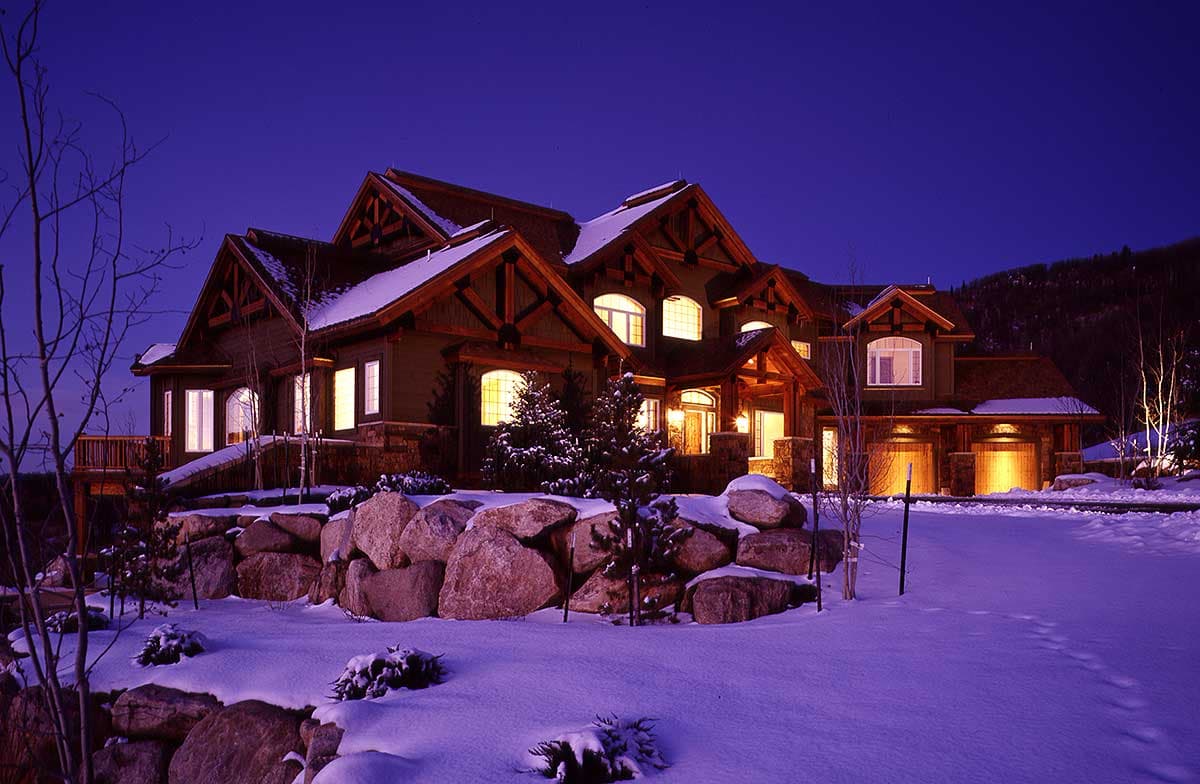 House plan exterior featuring multiple gables, exposed timber framing, a covered entry, and a three-car garage.