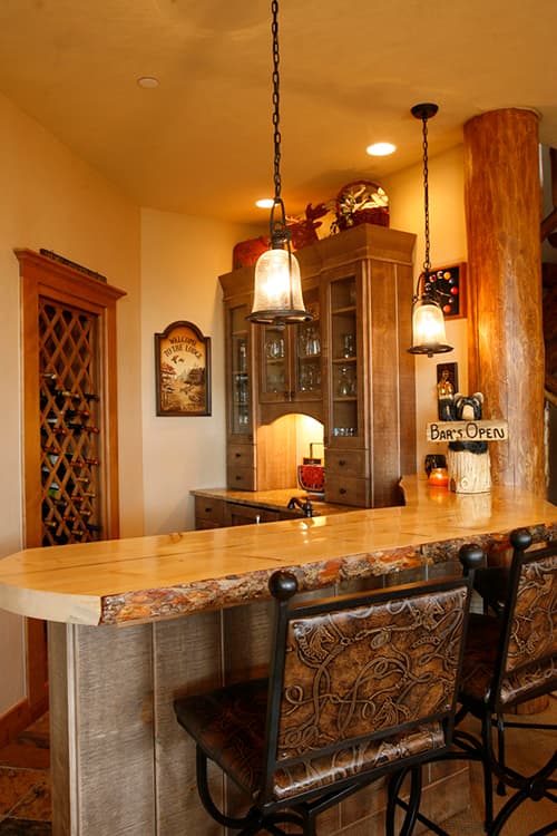 Bar area with live-edge wood counter, wood cabinetry, and wine rack.