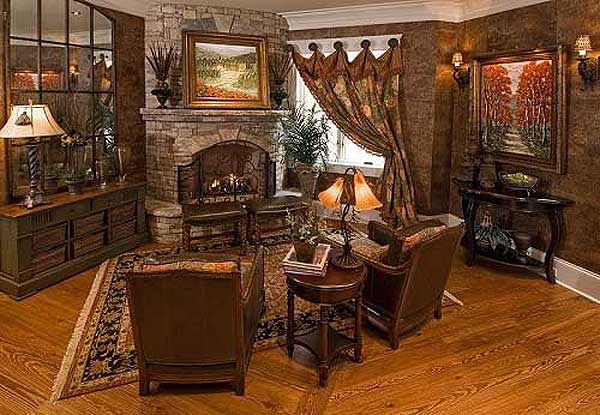 Living room with stone fireplace, large arched mirror, and patterned drapes.