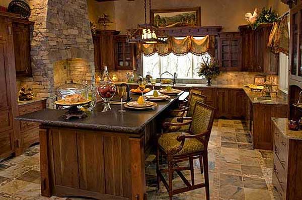 Kitchen with large stone fireplace, dark wood cabinetry, granite countertops, and a central island with seating.