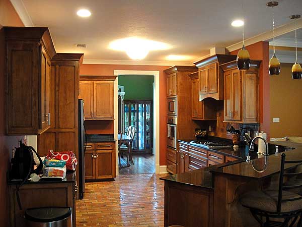 Kitchen with dark wood cabinetry, granite countertops, and a breakfast bar with pendant lighting.
