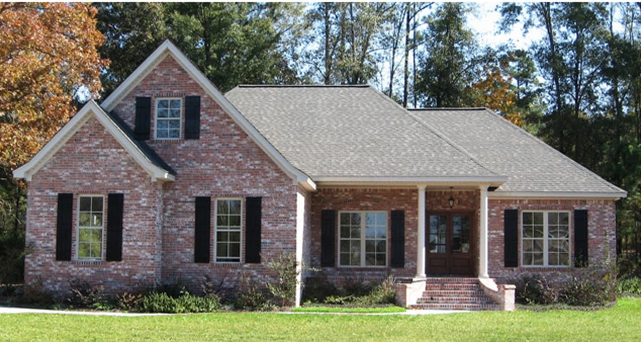 House plan exterior: brick two-story home with gables, dormer, covered front porch with columns, and multi-pane windows.