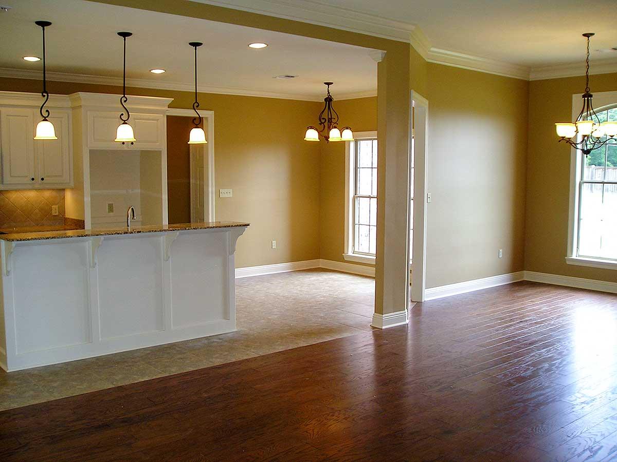 Interior view of open concept living space with kitchen island, pendant lights, and hardwood floors.