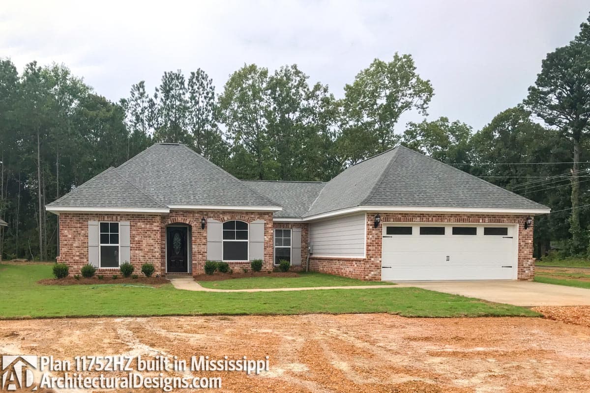 Ranch house plan exterior with brick and siding, a covered entry, and a side-facing garage. 
