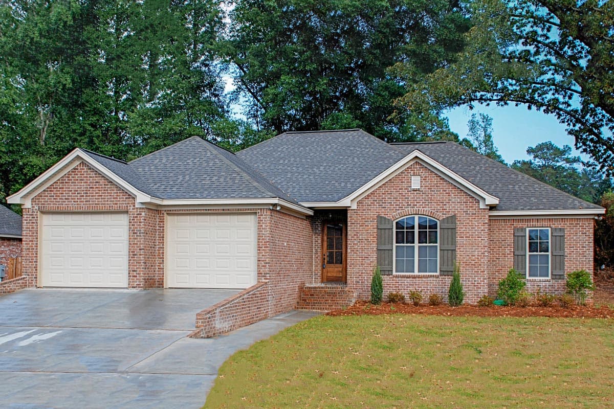 House plan exterior: Ranch-style brick home with a three-car garage, gabled roofs, and arched windows.