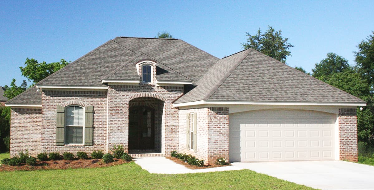House plan exterior: One-story brick home with arched entry, dormer, and attached two-car garage.