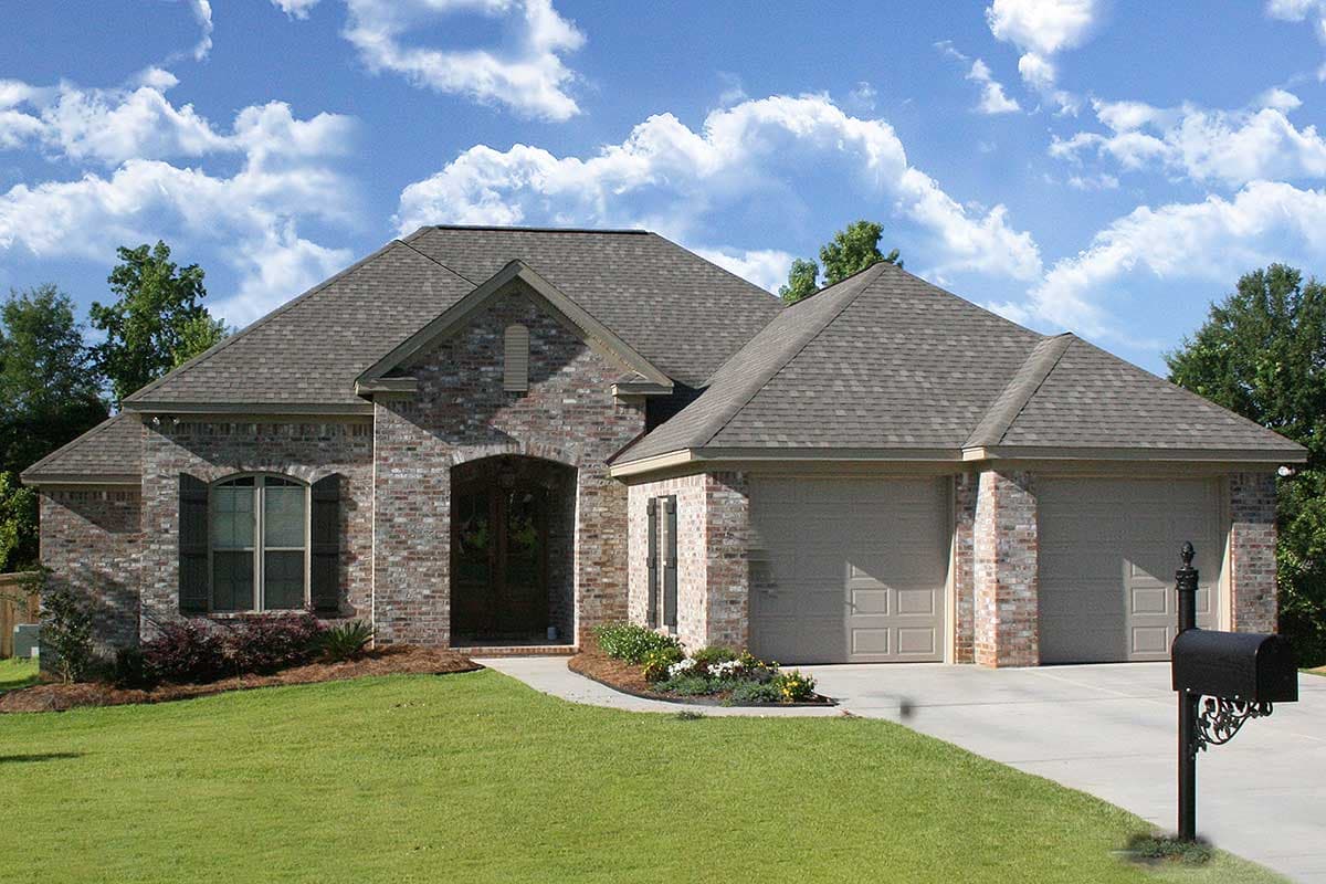 House plan exterior: One-story brick home with arched entryway, gable dormer, and attached three-car garage.