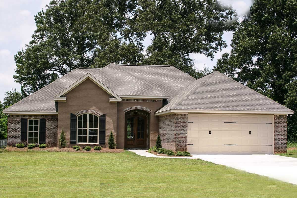 House plan exterior: Ranch style, brick facade, arched entryway, large gabled dormer, and attached two-car garage.