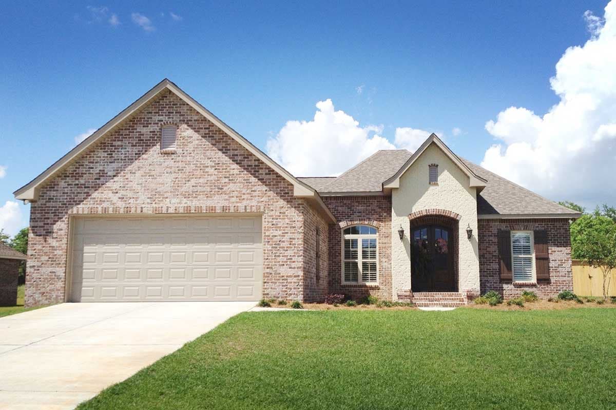 House plan exterior: Brick ranch with attached garage, arched entryway, and prominent gables.