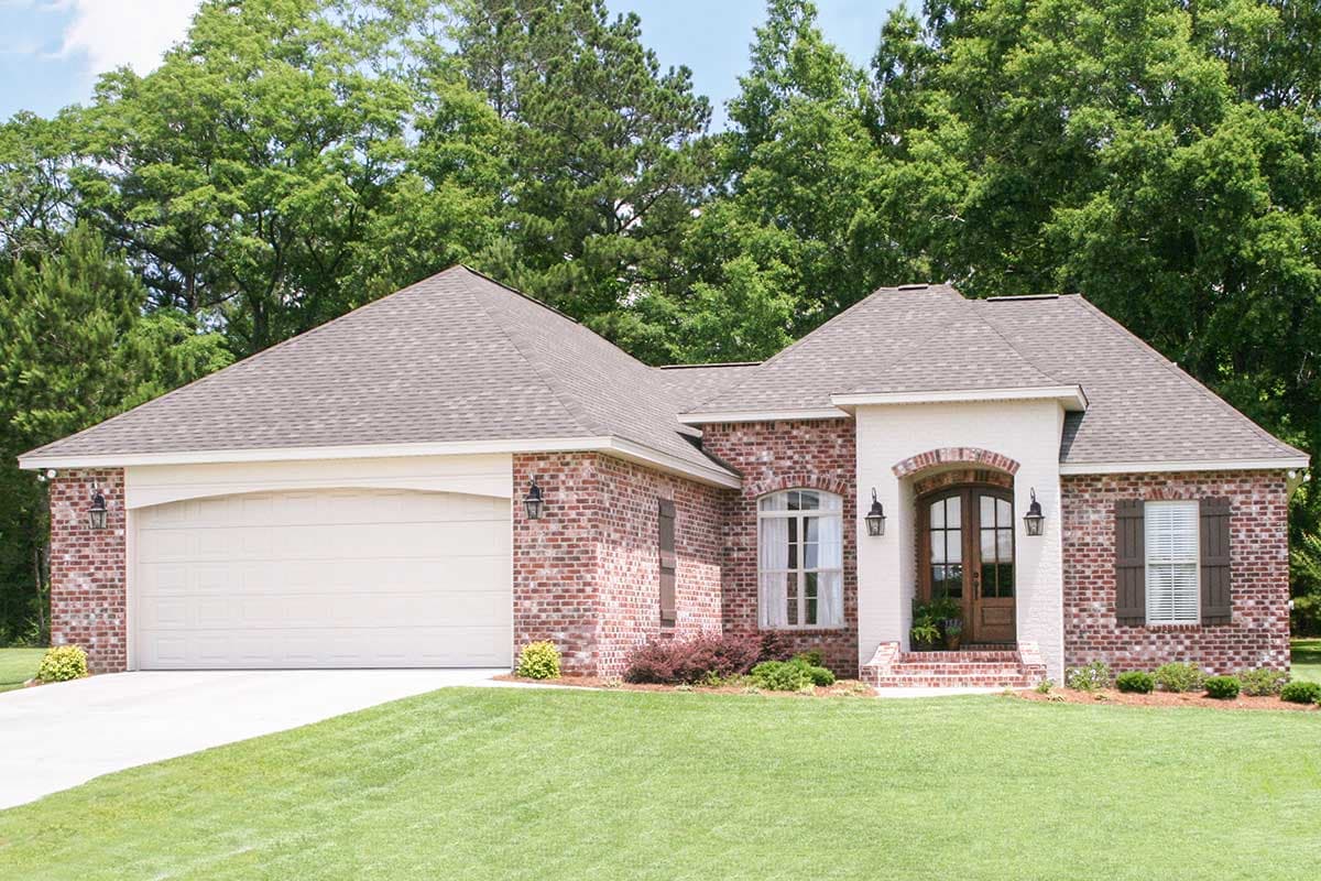 House plan exterior featuring red brick facade, single-story structure, attached garage, arched entry, and brick gable accents.