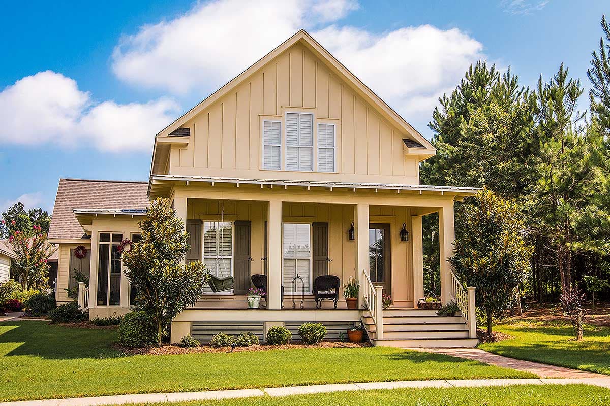 House plan exterior. Two-story Craftsman home with a front porch, gabled roof, and shuttered windows. Includes a visible garage.