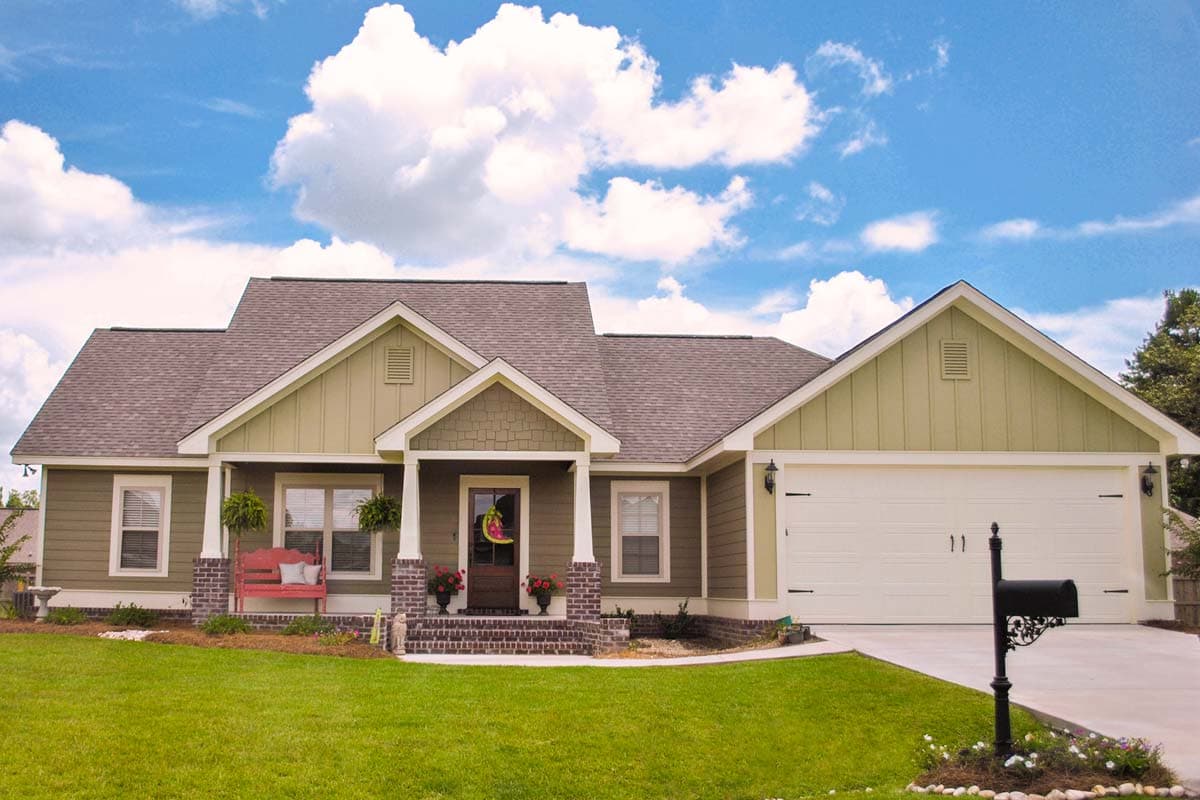 House plan exterior: one-story Modern Farmhouse with gabled dormers, covered front porch, and attached garage.
