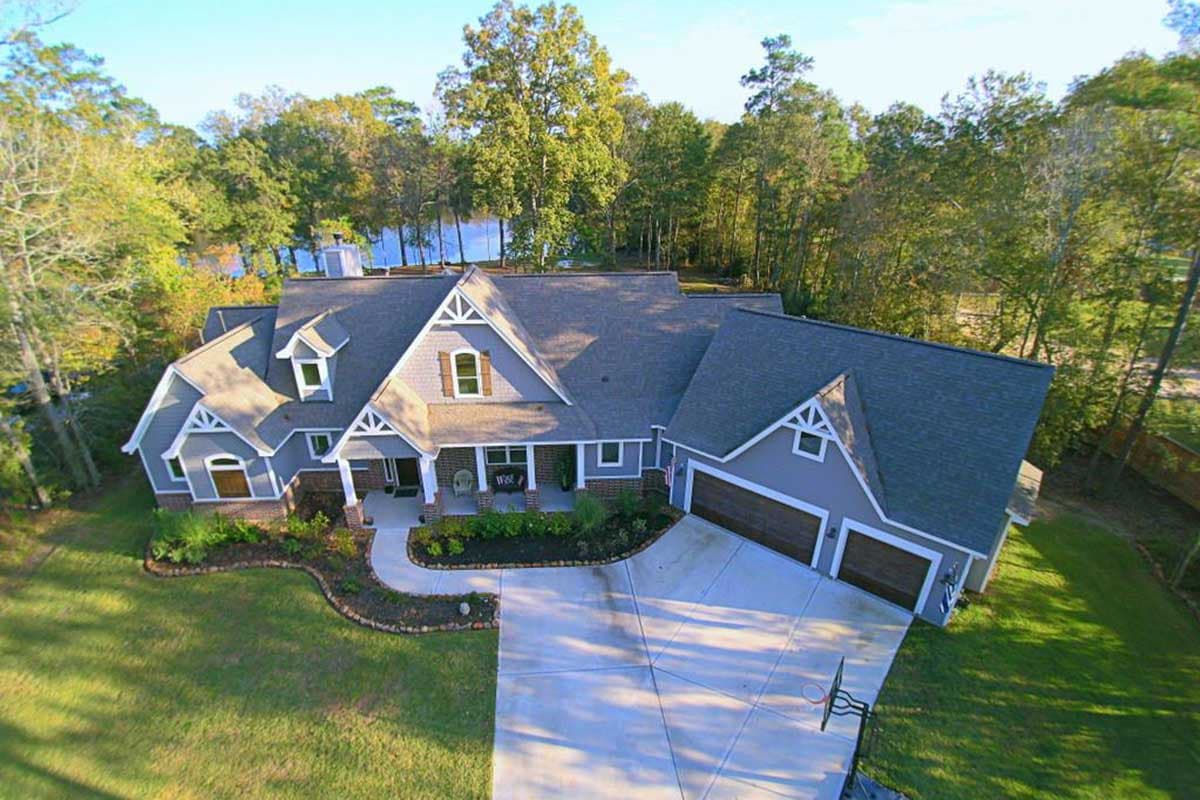 House plan exterior: Craftsman style, one-and-a-half stories, gabled dormers, covered front porch, attached three-car garage.