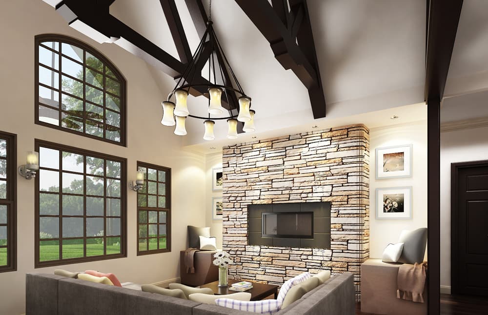 Interior view of a living room with a stone fireplace, large windows, and exposed wood beams.