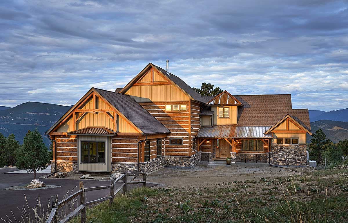 Log home exterior with stone accents, multiple gables, exposed rafter tails, and a covered front porch.