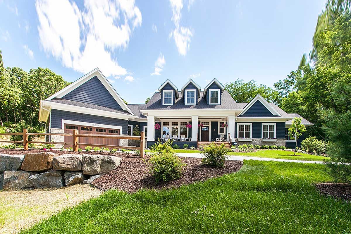 House plan exterior: blue-sided, 1.5-story Modern Farmhouse with gabled dormers, a covered front porch, and a side-facing garage.