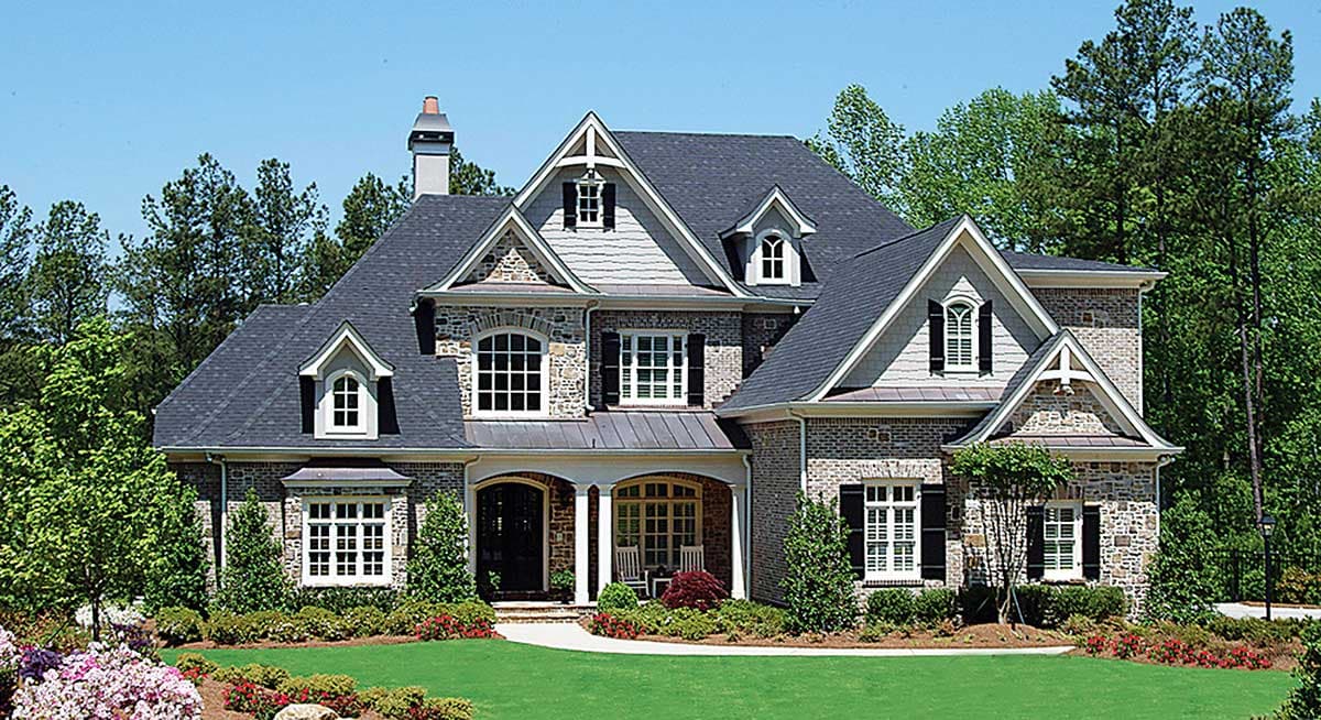 House plan exterior: Two-story home with stone and brick facade, gabled dormers, arched windows, and covered front porch.