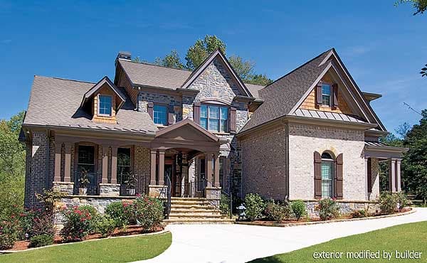House plan exterior with stone and brick facade, prominent gables, covered porch with columns, and dormer windows.