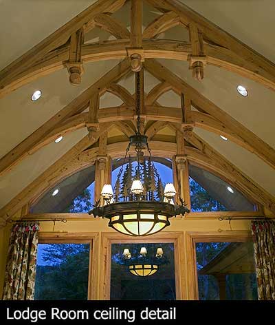 Lodge room ceiling detail with exposed timber beams, vaulted ceiling, and a rustic chandelier.