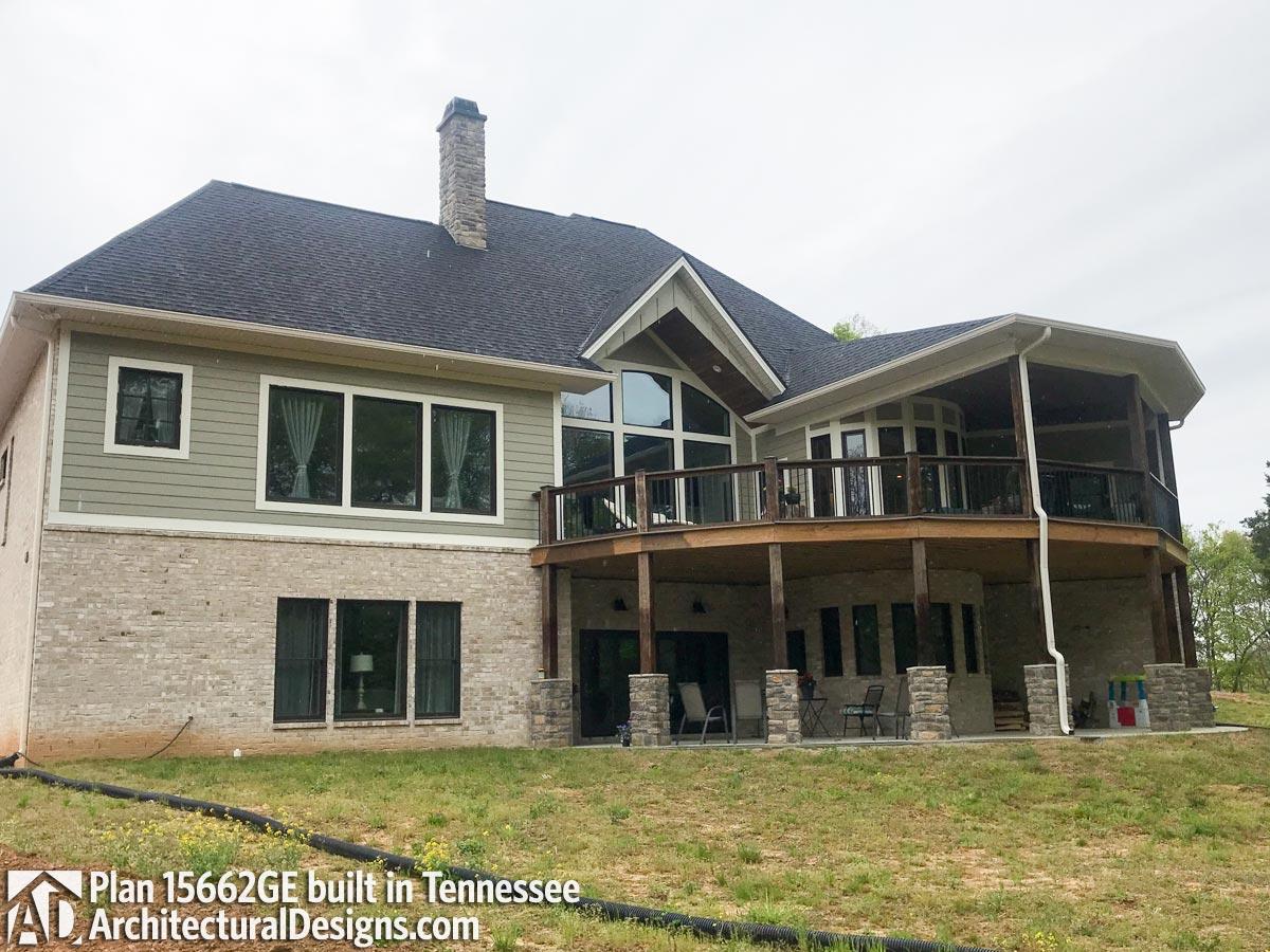 House plan exterior with stone and siding, multi-level deck, stone chimney, and large windows.