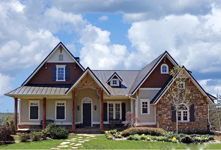 House plan exterior with stacked stone accents, gables, metal roof, and covered front porch with timber posts.
