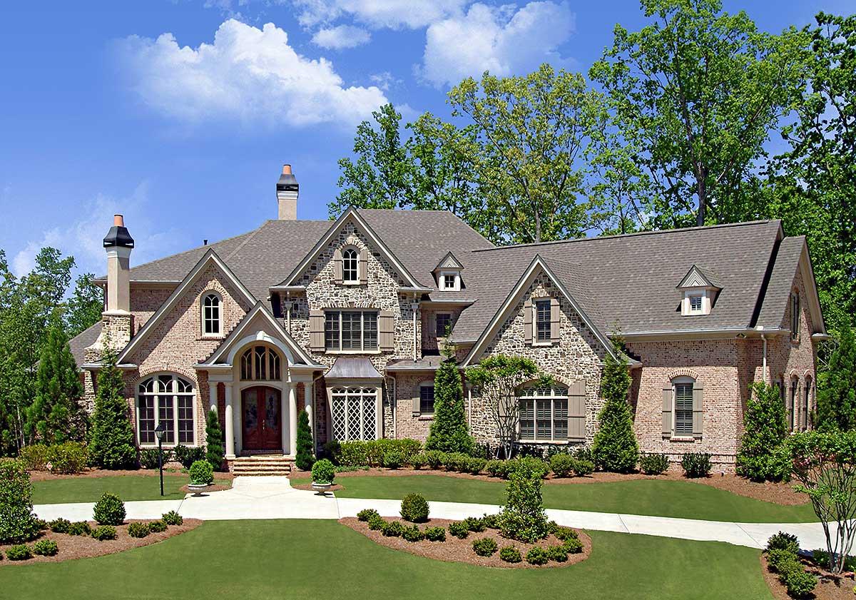 House plan exterior: Stone and brick facade, multiple gables, arched entryway, and dormer windows.