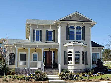 Two-story house plan exterior with a wraparound porch, multiple gables, arched windows, and bay window.