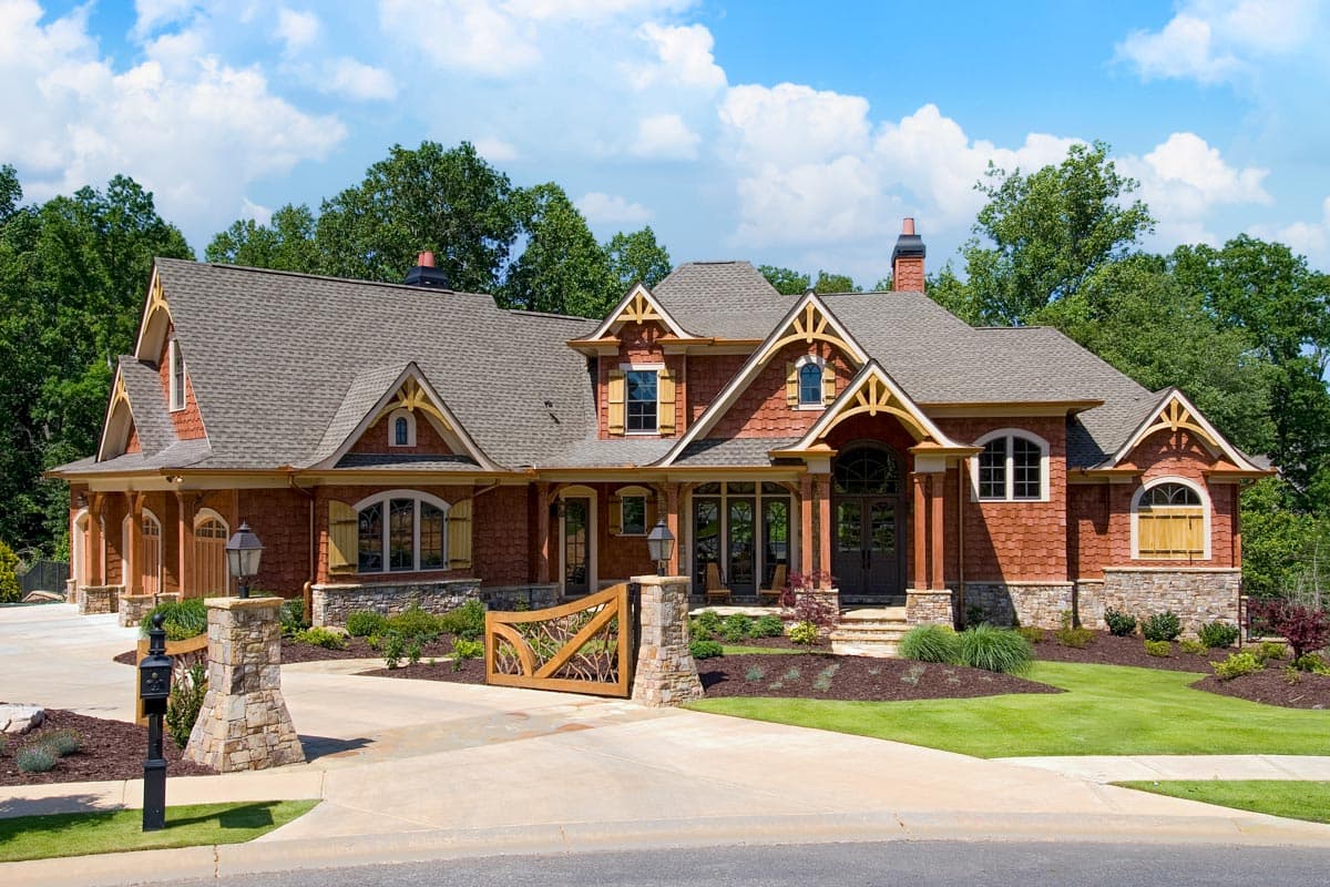 House plan exterior: Two-story home with multiple gables, arched windows, stone accents, and a covered porch.