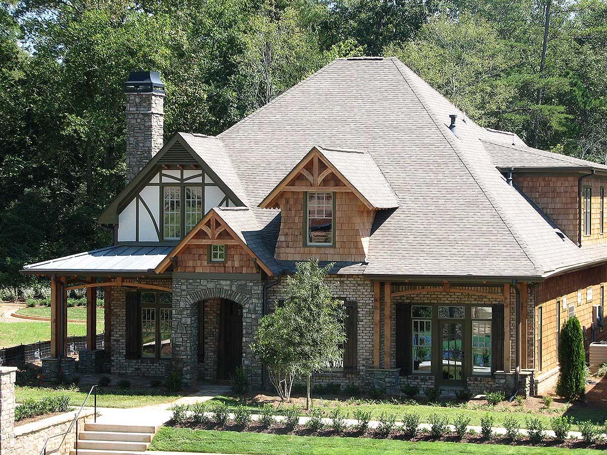 Craftsman style house plan exterior with stone and shingle siding, multiple gables, and covered porch.