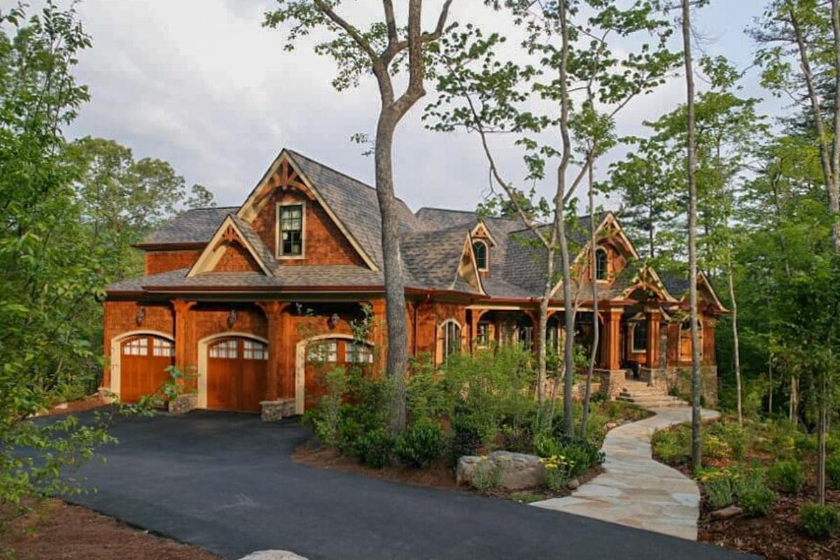 Mountain lodge style house plan exterior with triple garage, gabled dormers, and covered porch.