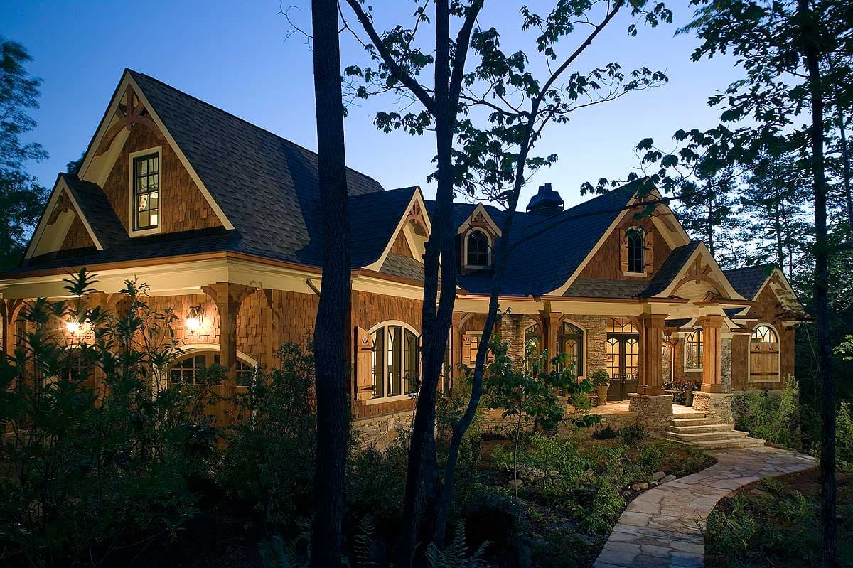 Craftsman style house plan exterior with wood shake siding, stone accents, arched windows, dormers, and covered porches.