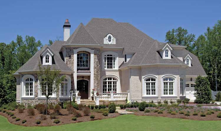 House plan exterior: Traditional style, two-story home with arched windows, stone accents, multiple gables, and a dormer.
