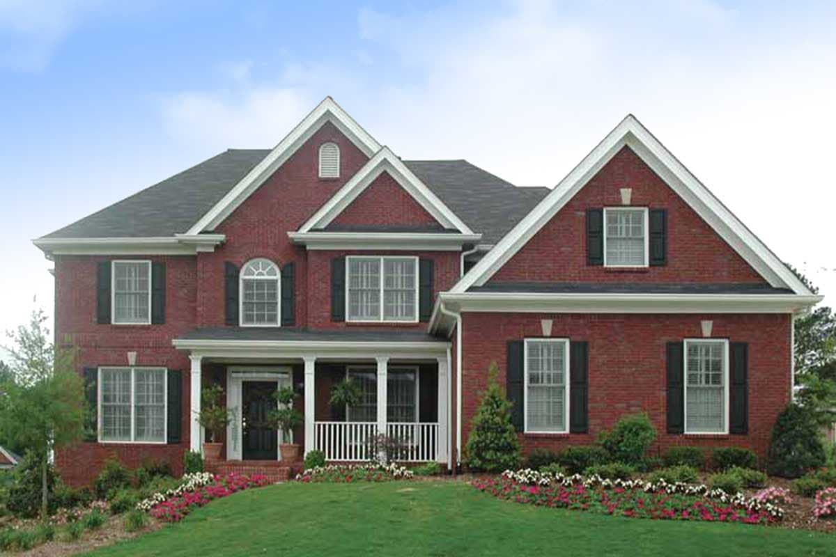 Two-story red brick house plan with a covered front porch, multiple gables, arched window, and shutters.