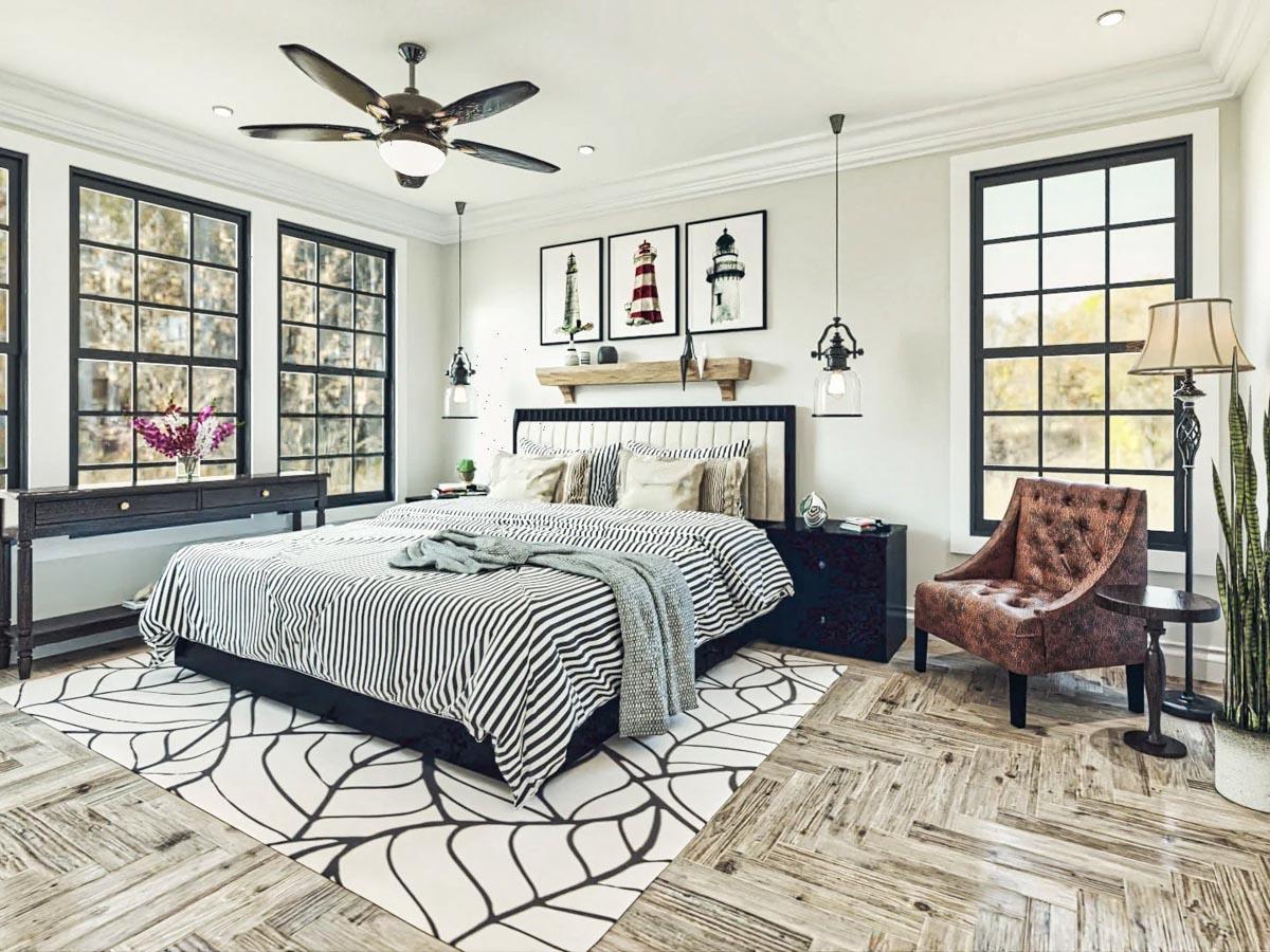 Primary bedroom with striped bedding, large grid windows, ceiling fan, and nautical art.