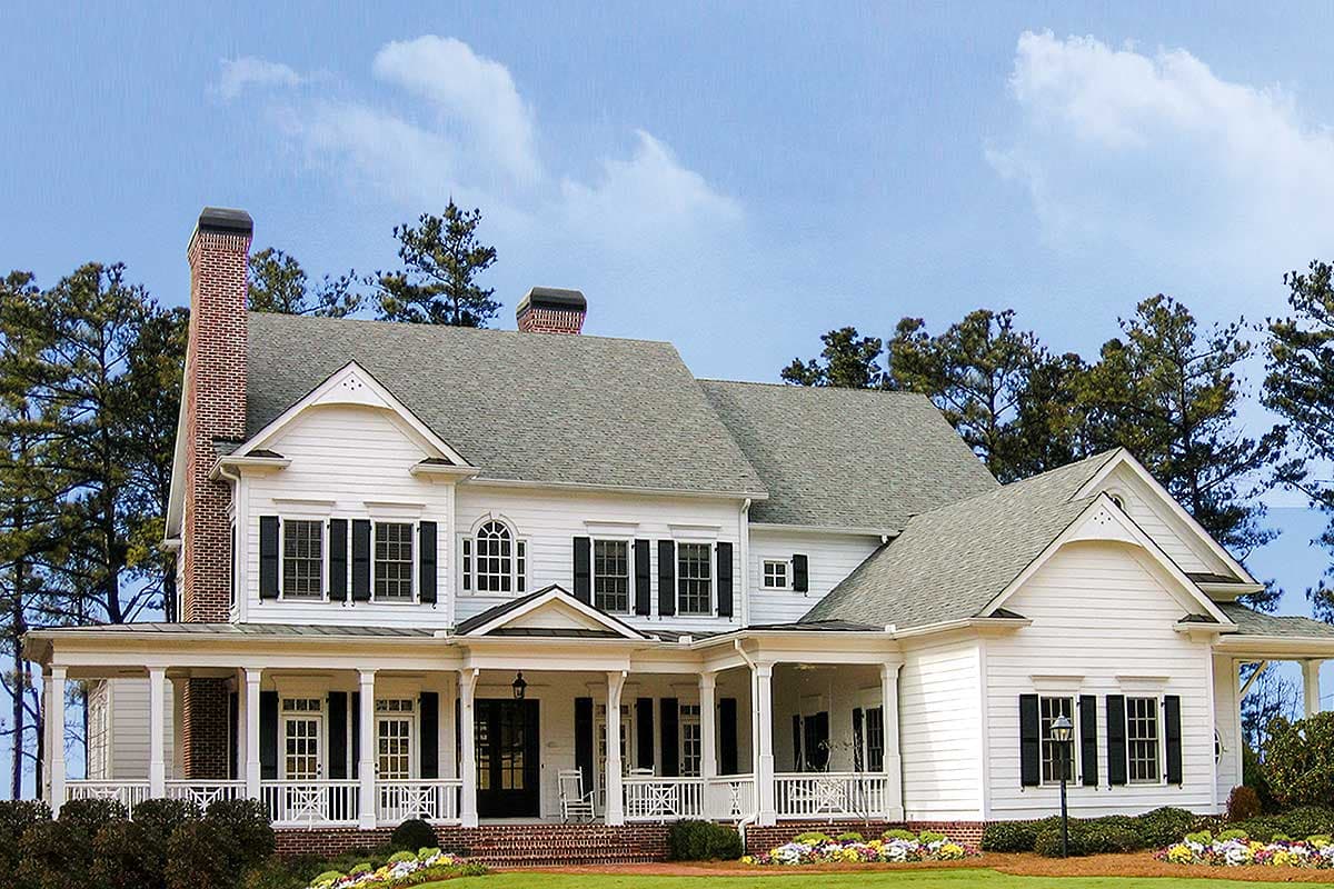 House plan exterior: Two-story white house with wraparound porch, multiple gables, dormers, and a brick chimney.
