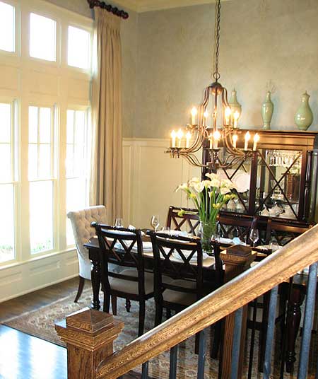 Dining room with large windows, formal dining table and chairs, a buffet, and a chandelier.