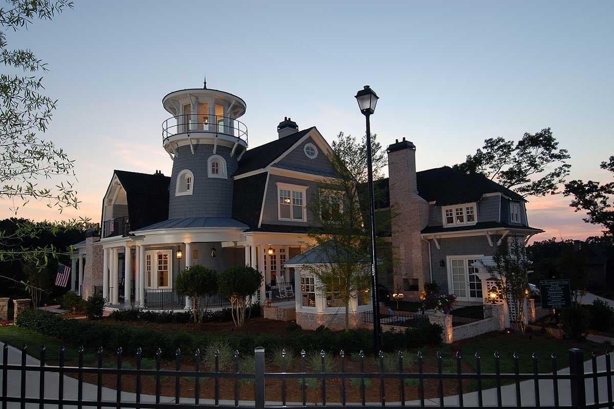 House plan exterior featuring a lighthouse-style tower, multiple gables, a prominent chimney, and a wraparound porch.