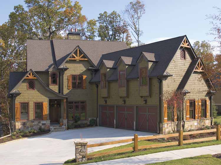 House plan exterior: Two-story Craftsman-style home with triple garage, multiple gables, dormers, and stone accents.