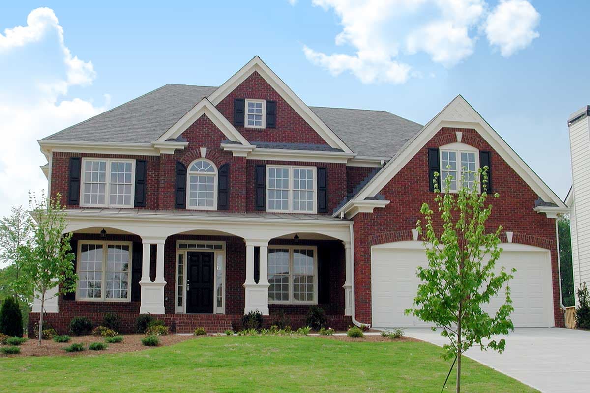 Two-story brick house plan exterior with gabled dormers, covered entry porch, and attached garage.