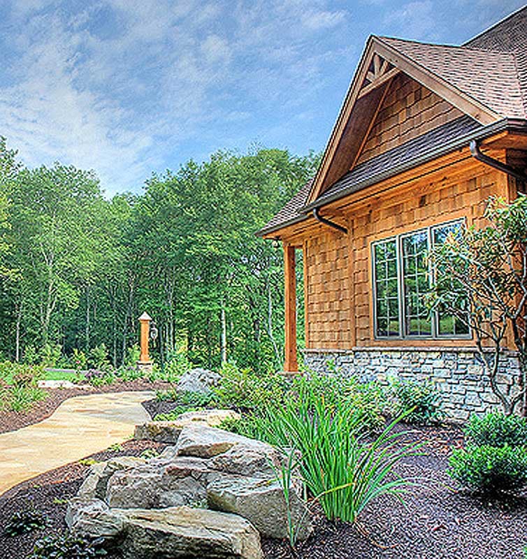 Craftsman style house plan exterior with cedar shingles, stone foundation, multiple gables, and a covered porch.