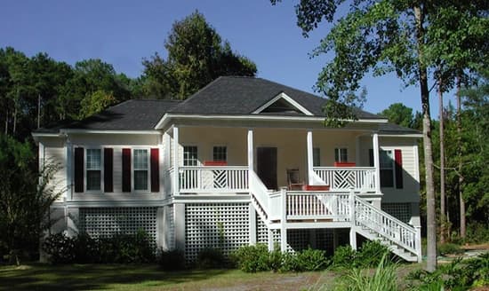 House plan exterior: One-story traditional home with wraparound porch, gable vent, and lattice skirting.