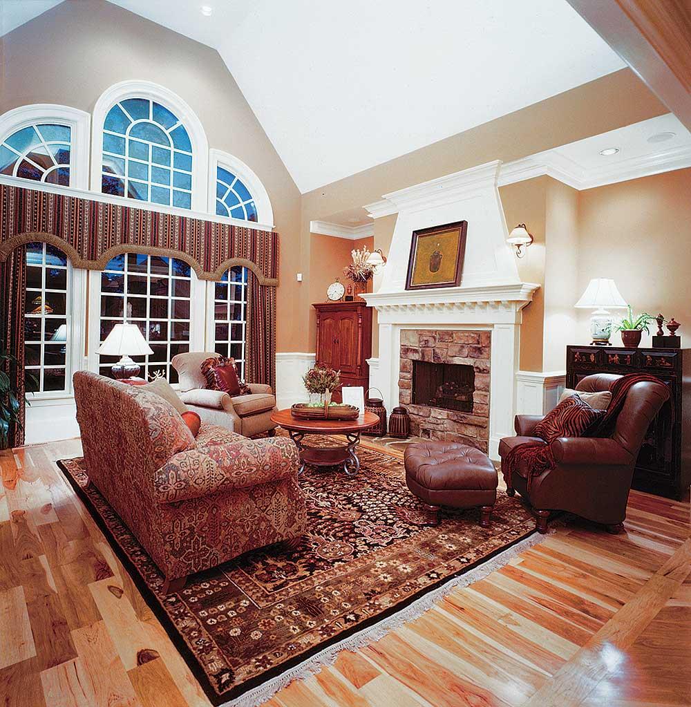 Great room with stone fireplace, vaulted ceiling, and arched windows.