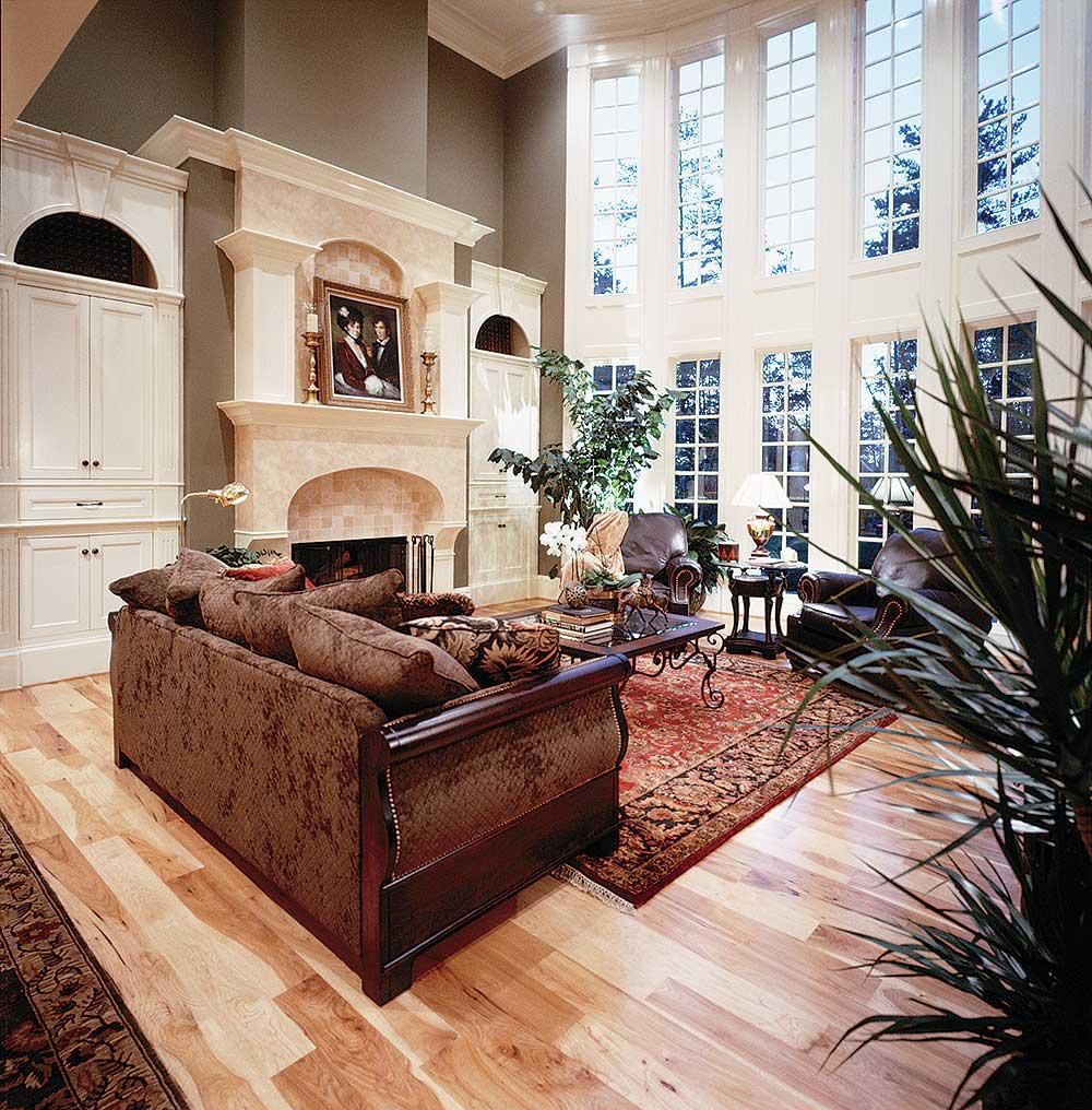 Living room with fireplace, built-in cabinetry, and tall windows.