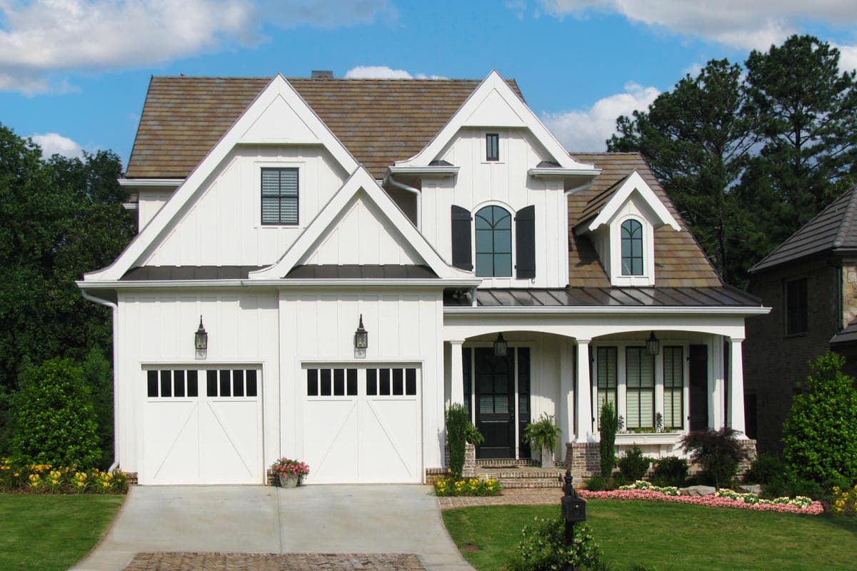 Modern Farmhouse house plan exterior with board and batten siding, a prominent gable, two garage doors, and a covered front porch.