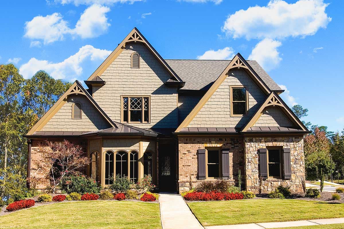 House plan exterior: Two-story home with stone and shingle facade, prominent gables, dormer windows, and arched entryway.