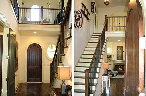 Interior view of a two-story foyer with a curved staircase, arched door, and second-floor balcony.