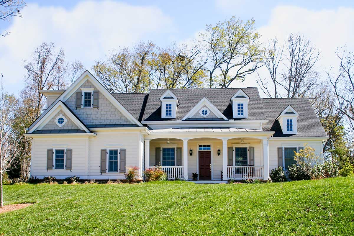 House plan exterior: Two-story Modern Farmhouse with wrap-around porch, multiple gables, dormers, and shingle and siding details.