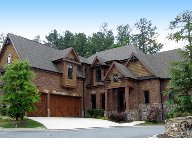 House plan exterior of a two-story brick home with a covered entryway, multiple gables, shingle siding accents, and a side-facing three-car garage.