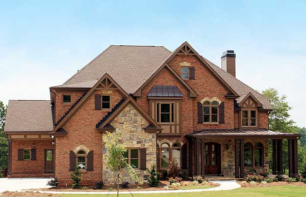 Traditional style house plan exterior with brick and stone facade, multi-level roof, front porch, and dormers.